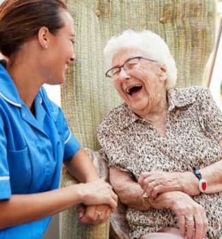 An assisted living nurse laughing with one of her clients