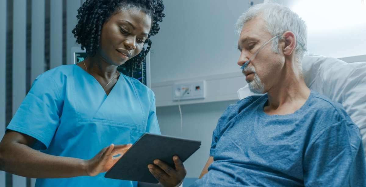 Bedside nurse with elderly male patient