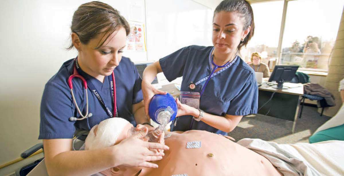 A couple of students in the HFU ABSN program performing an exercise during their on campus residency